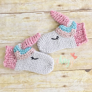 a unicorn mittens in wood background