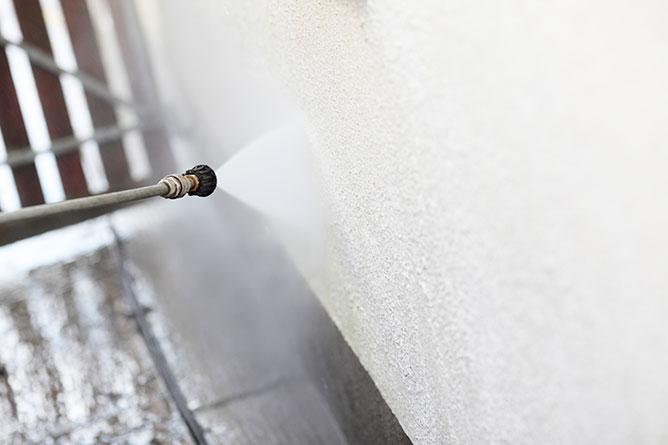 Weserve, a power washer hose cleaning the outside wall of a house