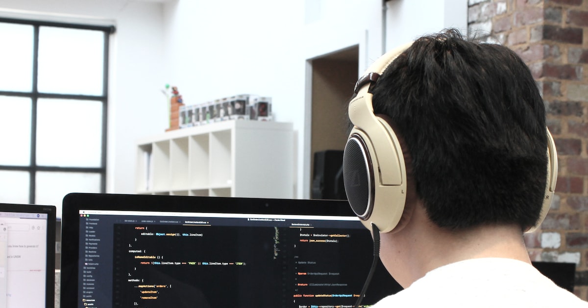 Man in headphones writes code on a computer