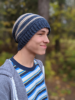 teen wearing a blue and cream striped crochet beanie