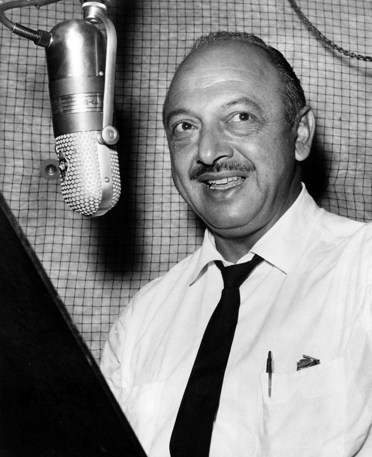Mel Blanc in the recording studio speaking into a microphone.