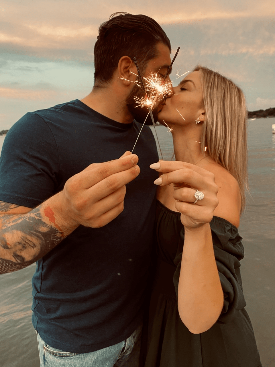 Cassandra and Anthony kiss each other and holding sparkler in his hand
