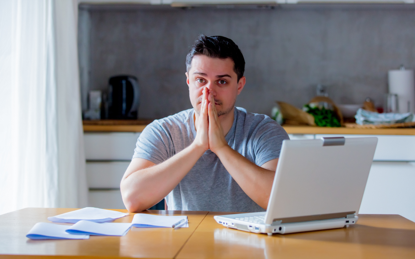 A person sitting at a table with his hands togetherDescription automatically generated with medium confidence