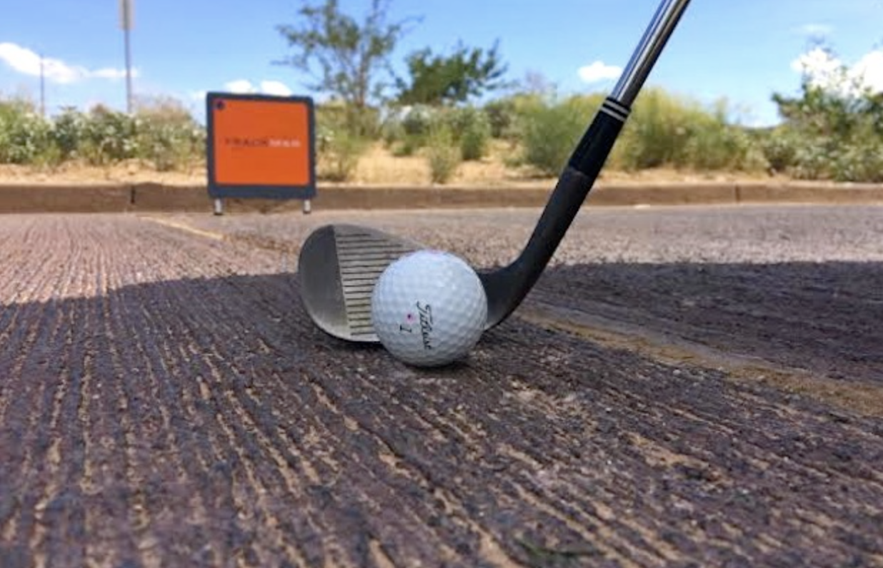 golf ball with club on cement ground