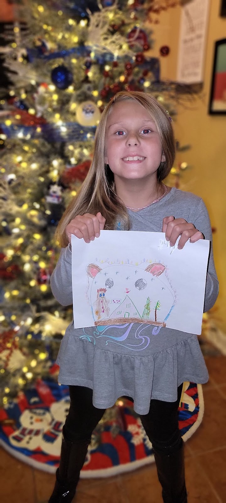 the winner of our holiday card contest, Gabriella, poses with her drawing