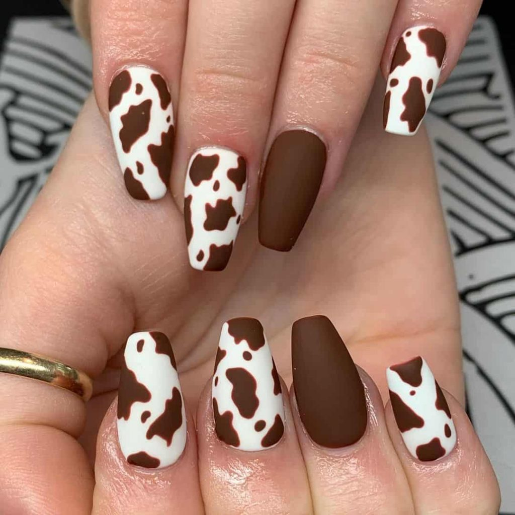 Close up photo  of a gorgeous  brown cow print nail design