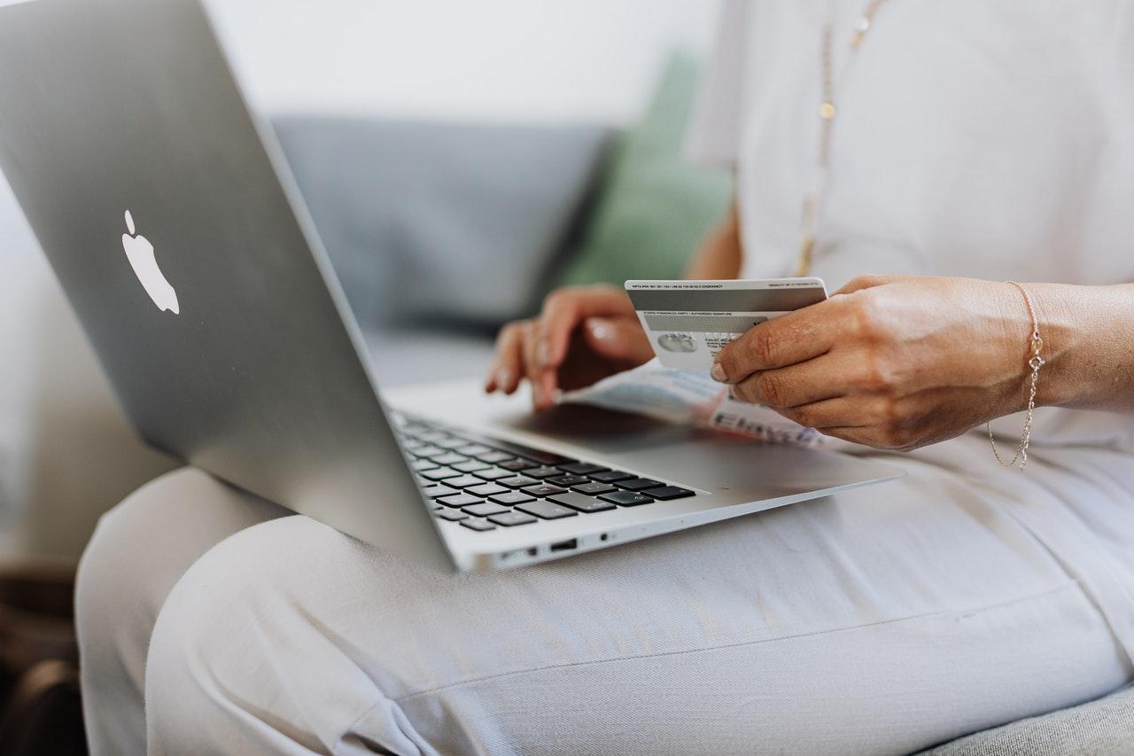 A woman using her laptop and holding her credit card