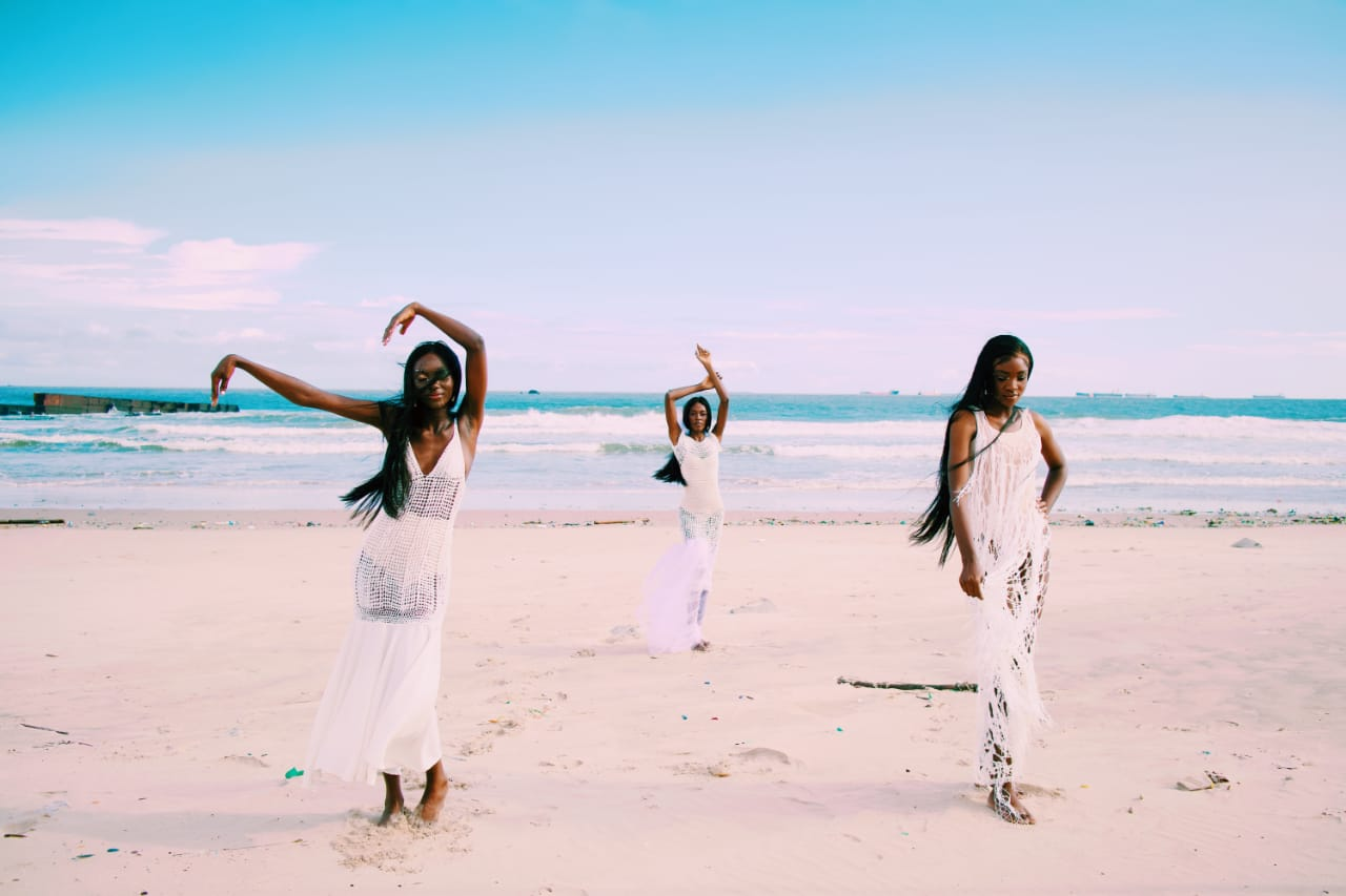 Female models wearing crocheted dresses running by the beach as featured in Pink Noise: a fashion film
