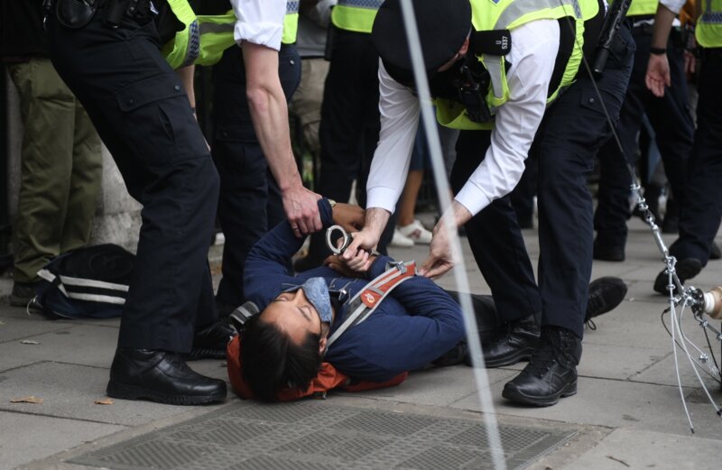 Police arresting a rebel lying on the floor