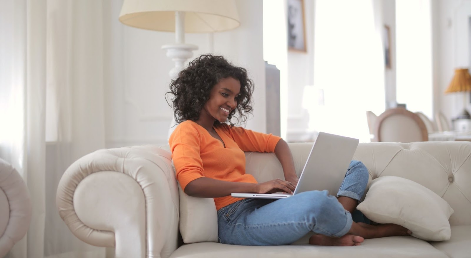 girl on couch with laptop registering for Safe Travels Hawaii