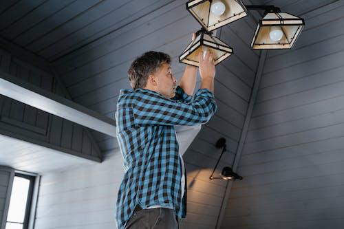 Free A Man Installing a Light Bulb Stock Photo