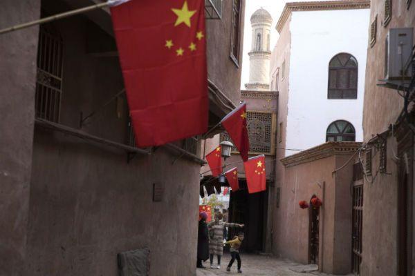 新疆喀什市家家挂有中国国旗。中国官方严管网络言论，防止被极端穆斯林言论影响。（美联社）