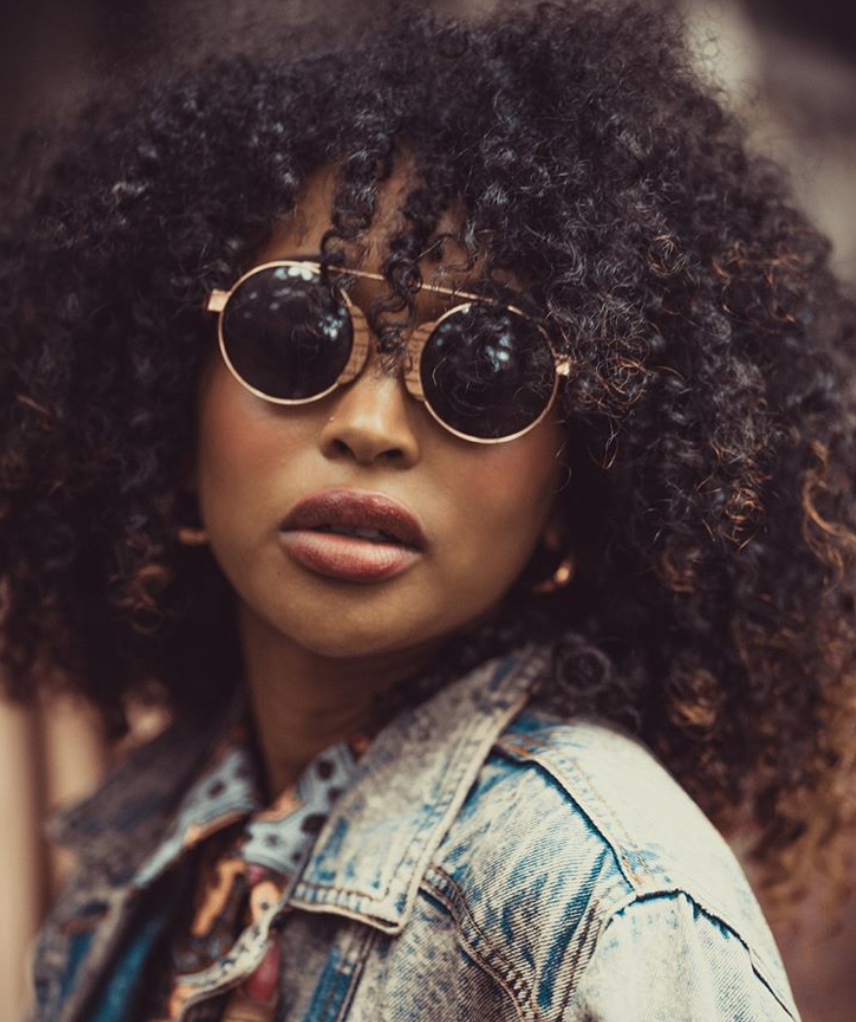 A close up of a person wearing sunglassesDescription automatically generated