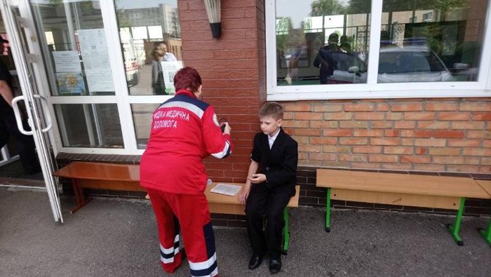 Врач скорой помощи осматривает школьника, которому стало плохо во время линейки в Черкассах
