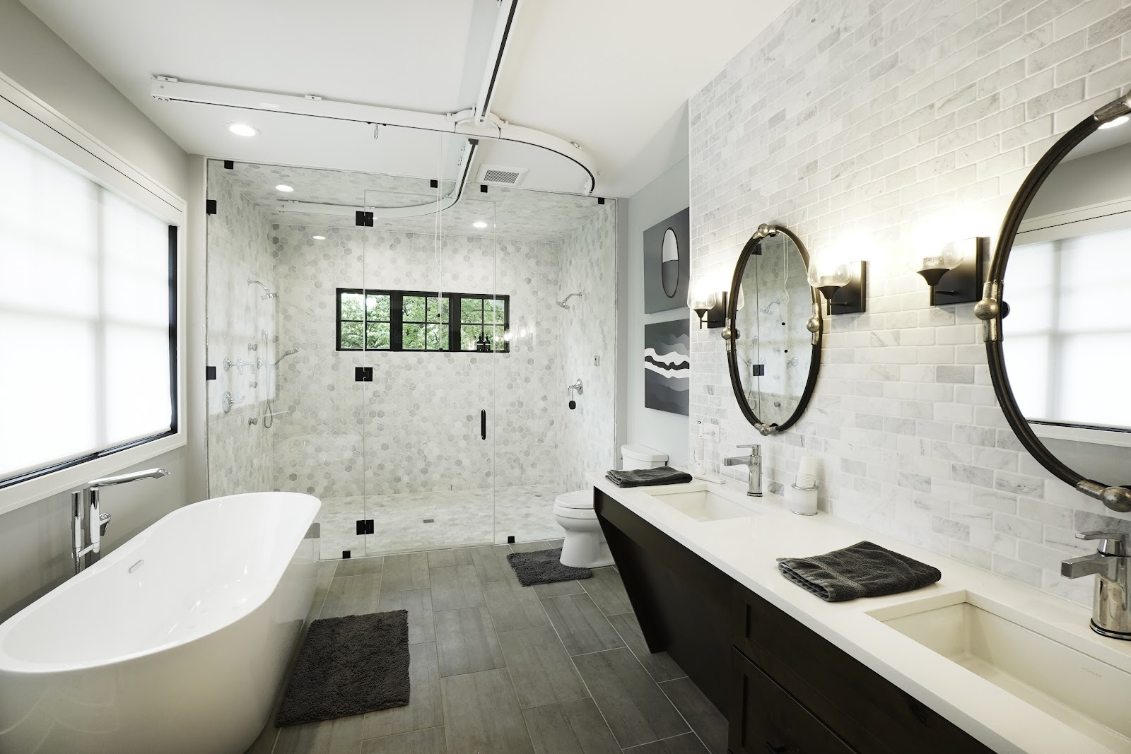 Barrier-free-bath-with-carrara-marble-tile-walls-and-large-barrier-free-shower-featuring-a-large-soaker-tube-walnut-vanity-with-quartz-countertops-and-ceiling-lift