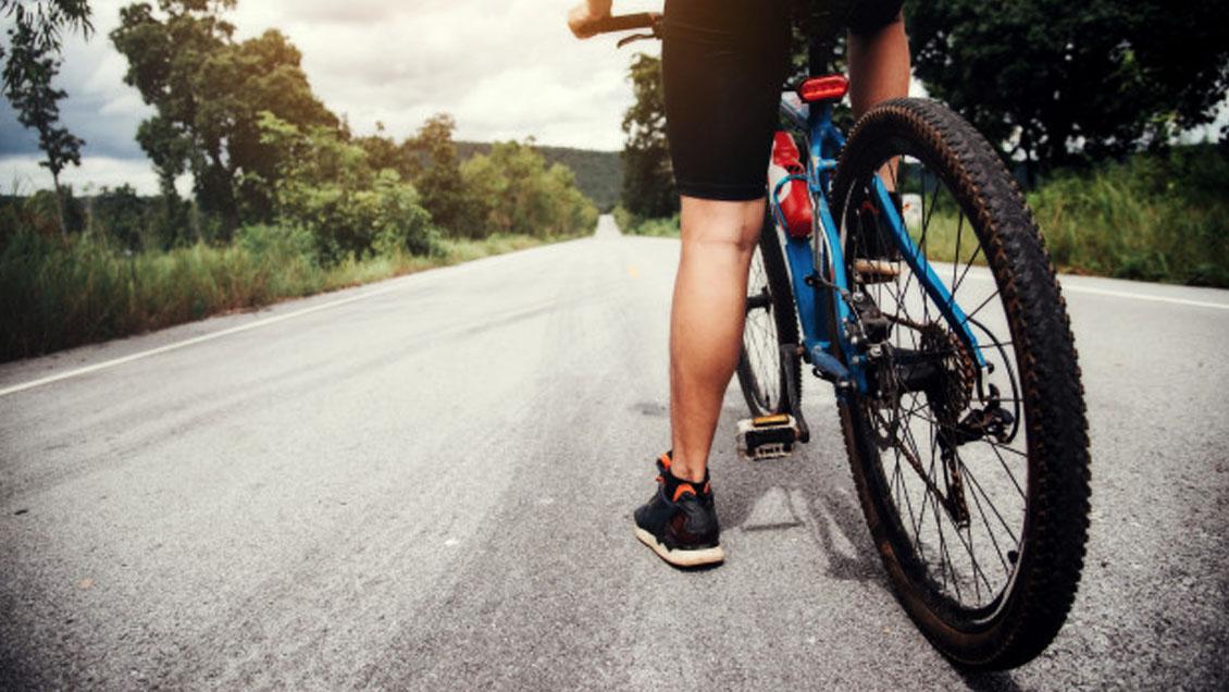 A person riding a bicycle on a road

Description automatically generated