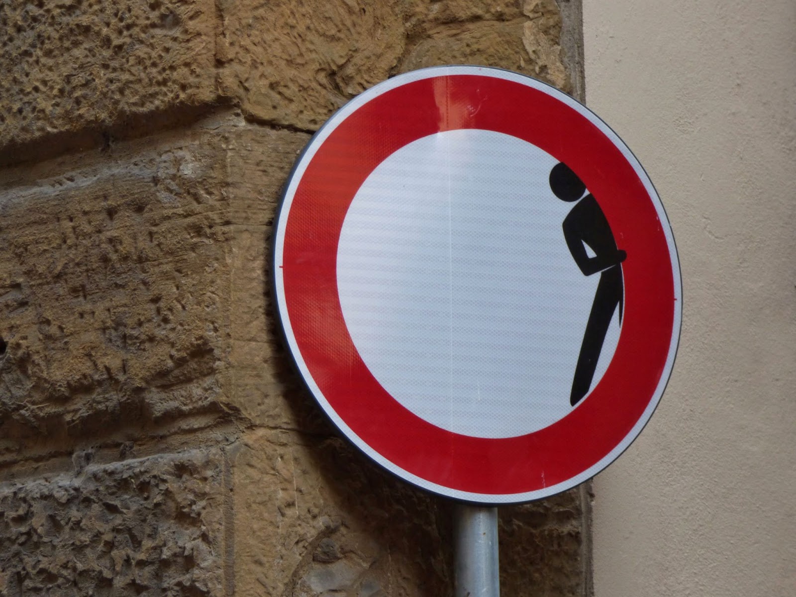 Red circular road sign with peeking man