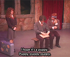 Harry and Ron from A Very Potter Sequel sitting on a bench while Hermione watches them open the present they gave her. Ron and Harry say "I hope it's a puppy. Puppy, puppy, puppy."
