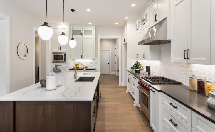 A newly remodeled kitchen with a kitchen island and pendant lighting