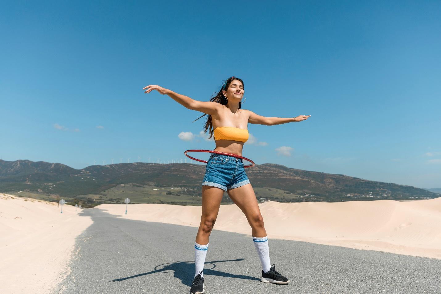 A person in a blue shirt throwing a frisbee at the beach

Description automatically generated