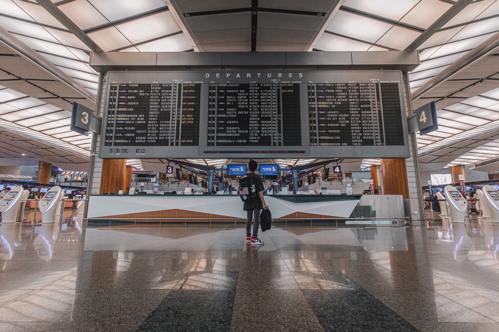 Traveller gazing at the big display screen at airport