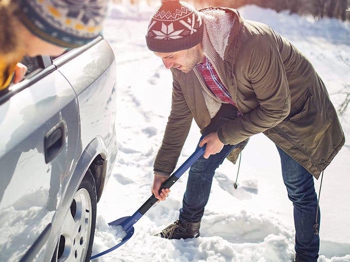 Image of man in winter hat using Lifeline Aluminum Sport Utility to dig out his car for best snow shovel 2021