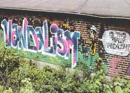Posprejovaná zeď s nápisem "Vandalism". 