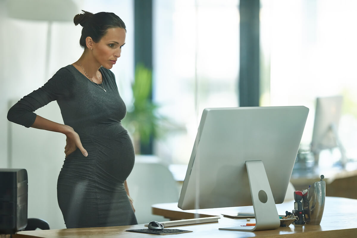 FMLA NY: pregnant executive working at her office