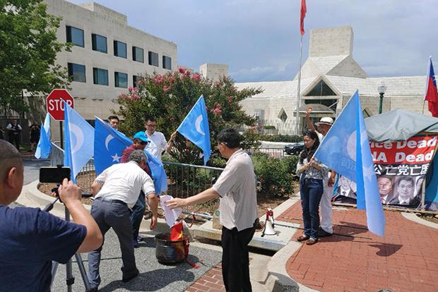 维吾尔族人在同一地点反对中共新疆政策的示威，示威者还当场焚烧了中共党旗。（伊利夏提提供）