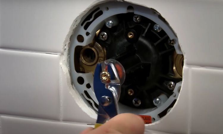 adjust the temperature setting on the shower valve