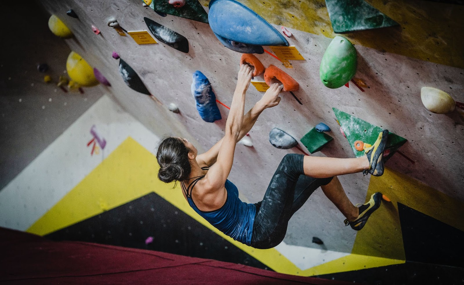 Woman on indoor rock climbing wall at gym in Kelowna.
