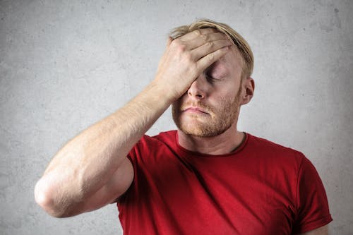 Free A Man in Red Shirt Covering His Face  Stock Photo