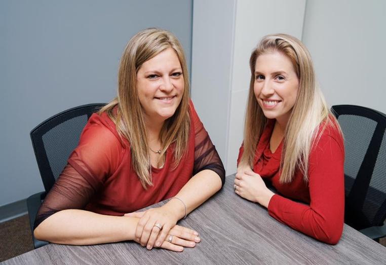 A couple of women sitting at a table

Description automatically generated with medium confidence