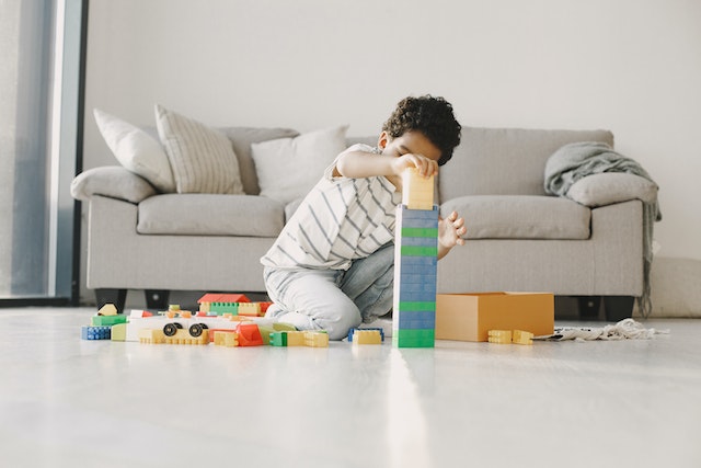 young boy building blocks in living room
