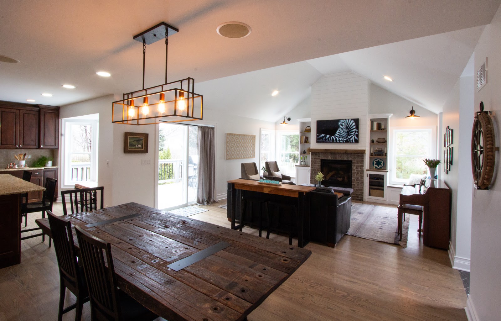 Open floor plan interior with kitchen, large farm dining table and family room