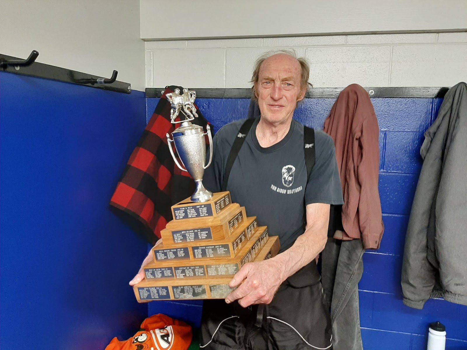 Tim Ross holding Oldtimer's Hockey League trophy.