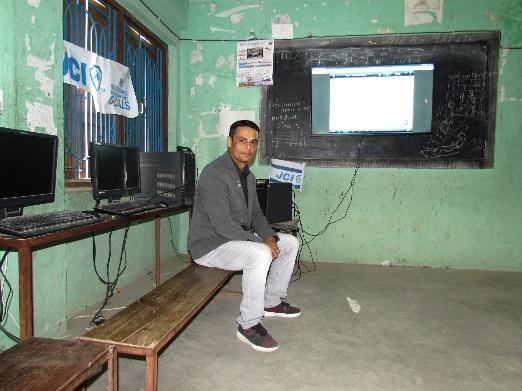 A person sitting on a bench in front of a computer screen

Description automatically generated