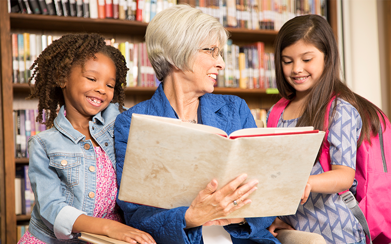 volunteer opportunities for seniors working with children like this woman reading books to kids helps reduce depression