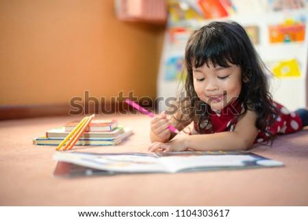 Little girl coloring her coloring books