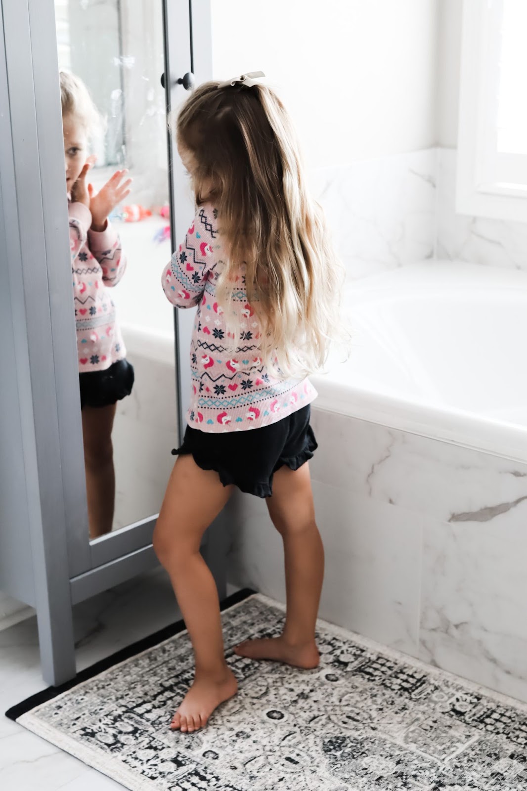 Medicine Cabinet Ideas by popular Atlanta lifestyle blog, City Peach: image of a little girl applying lipstick while looking at herself in a mirror. 