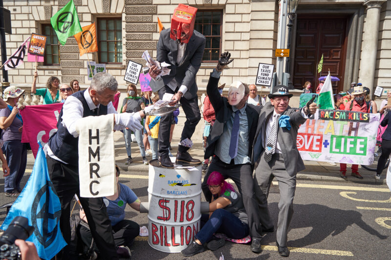 Scene of rebels costumed as HMRC, Boris Johnson, Barclay and dirty oil