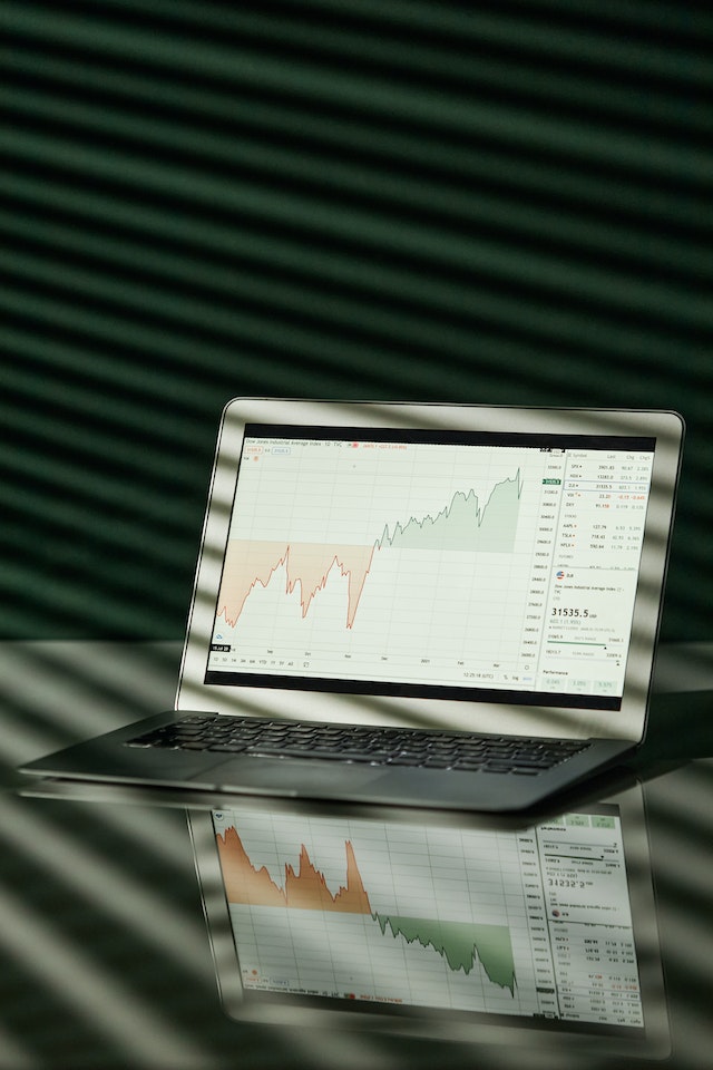 financial charts displayed on laptop