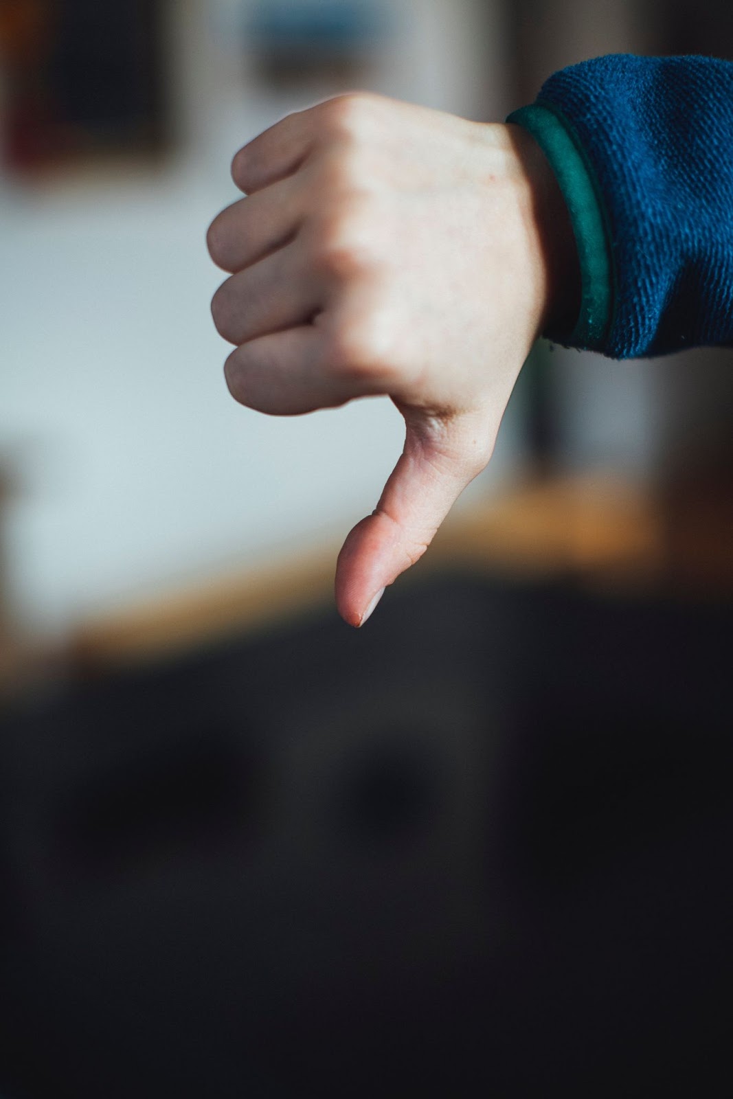 A hand making a fist with thumb down.