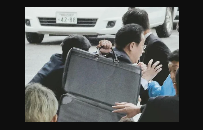 Hình ảnh thủ tướng đương nhiệm Kishida Fumio được các vệ sĩ bảo vệ trong vụ đánh boom.
