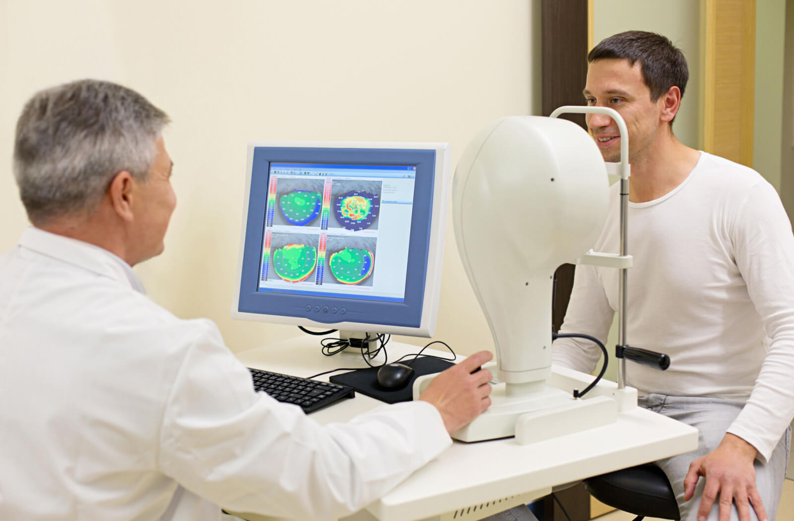 An eye doctor is running Corneal topography on a male patient with  Keratoconus