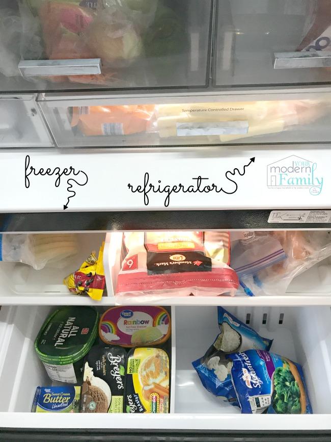 A close up of an open refrigerator and freezer with food organized in the drawers.