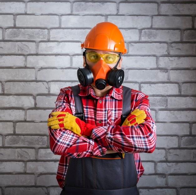 Retrato de trabalhador usando equipamento de proteção. construtor com equipamento de segurança contra superfície de parede de tijolo. Foto Premium