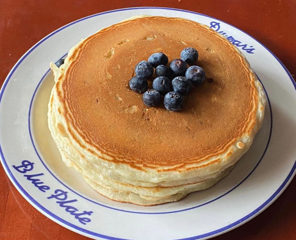 A white plate topped with a chocolate cake
Description automatically generated