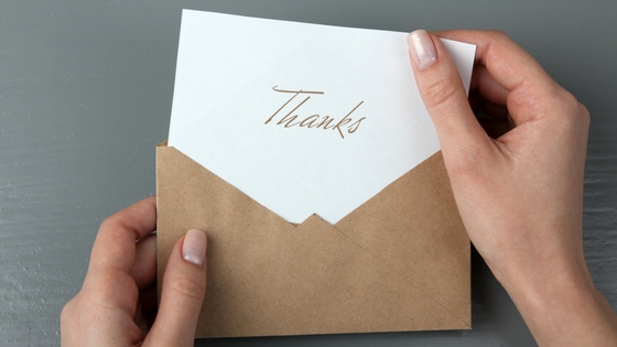 A thank you card partially within an envelope