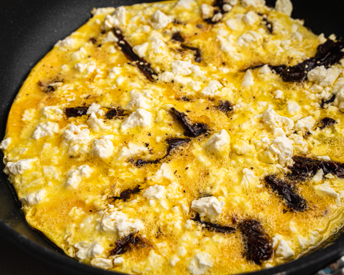 cooked eggs topped with sun-dried tomatoes and feta